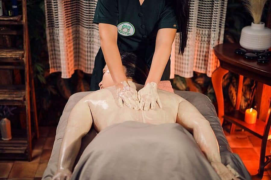 Terapeuta aplicando una envoltura corporal durante un masaje